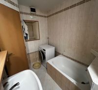 Bathroom with a bathtub, washing machine, and mirror in a 3-room apartment.
