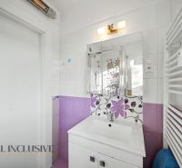 A bathroom in a 3-room apartment with floral tiles and white sanitary ware.