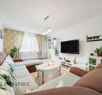 A living room with a comfortable sofa, television, and wooden decor flooring in a 3-room apartment.