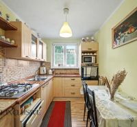 A kitchen in a 3-room apartment with a wooden decor floor and a dining table.