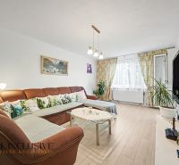 Living room in a 3-room apartment with a comfortable sofa and a television, floor with a wooden decor.