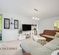 Living room in a 3-room apartment with a large sofa and a television on the wall.