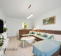 Living room in a 3-room apartment with a sofa, television, and a wooden decor floor.