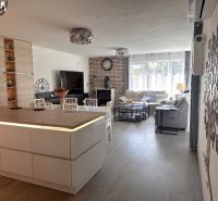 Living room with a kitchen island in a family house with a wooden decor floor.