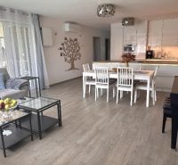 Living room of a family house with a wooden decor floor and a dining area.