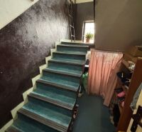 A staircase in a family house with textiles and decorations on the walls.