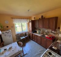 A kitchen in a family house with wooden decor on the kitchen unit and dining table.