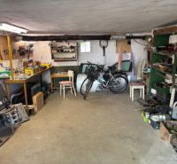 A garage with a workshop in a family house, equipped with workbenches and a bicycle.