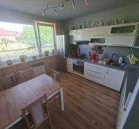 A kitchen with a wooden decor floor and a dining table in a 3-room apartment.