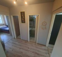 A hallway in a 3-room apartment with a wooden decor floor and a view into the bedroom.
