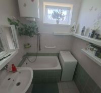 Bathroom with a bathtub, sink, washing machine, and window, 3-room apartment.