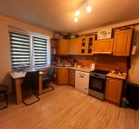Kitchen with dining table; 2-room apartment with wood-patterned flooring.