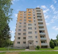 A high-rise building on SNP Street in Považská Bystrica surrounded by greenery.