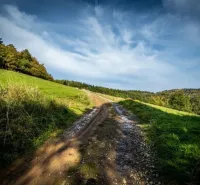 A gravel road in nature surrounded by greenery and forests in Banská Štiavnica.