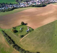 Aerial view of agricultural and forest land near Trenčianske Stankovce with a turret and trees.