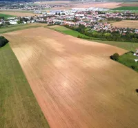 An aerial view of agricultural and forest lands in Trenčianske Stankovce with visible buildings.