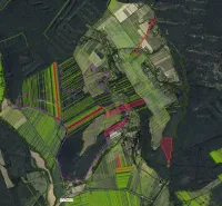 Aerial view of agricultural and forest lands in the village of Muľa, various shades of green.