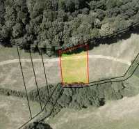 Aerial view of a fenced plot in the gardens of Horná Ves with surrounding trees.