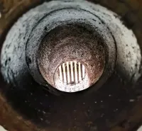 A view through a dark tunnel with a grate at the end in the interior of peculiar properties.