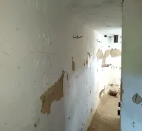 Abandoned narrow space with damaged walls, falling into the category of peculiar properties.