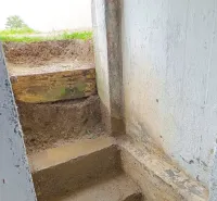 Stairs from the basement leading out of the property, surrounded by raw earth.