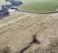 Agricultural and forest lands in Podhorany with scattered trees and water streams.