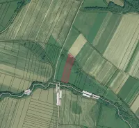 Aerial view of agricultural and forest lands around Podhorany with a river flowing through the landscape.