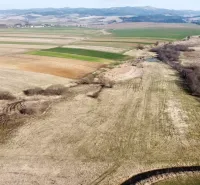 Agricultural and forest lands in Podhorany with meadows, fields, and surrounding hills.