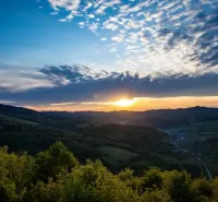 Sunset over agricultural and forest lands near Dohňany with dramatic clouds.