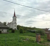 The church with a bell tower in Barca, surrounded by greenery and peculiar properties.