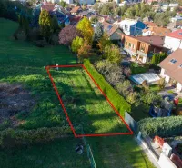 A plot in the Gardens of Banská Bystrica, surrounded by greenery and family houses.