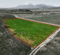 Agricultural and forest land in Podhorany with a green plot and mountain panorama.