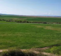 Green fields and roads in the agricultural and forest lands surrounding Podhorany.