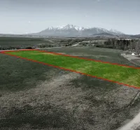 Agricultural and forest land in Podhorany with a view of snow-capped mountains.