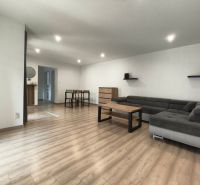 Living room in a family house with a wood-patterned floor and a comfortable sofa.