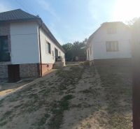 A family house in Dobroč with a garden and a white facade on a quiet street.