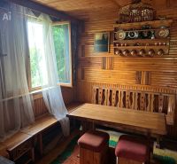 An interior with wooden walls and furniture, traditional decorations on the shelves.
