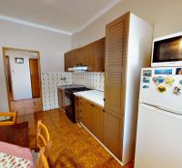 A kitchen in a family house with a wooden decor floor, furniture, and appliances.