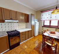 A kitchen in a family house with wooden cabinets and a floor with a wooden decor.
