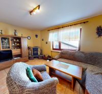 A living room in a family house with brown furniture and a fireplace, tiled floor.