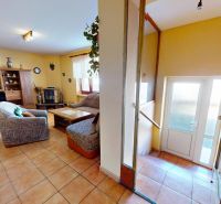 Living room with a fireplace and stairs in a family house, floor with wooden decor.