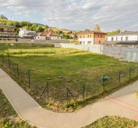 Plots - housing in the Kasárne District in Brezno with sidewalks and family houses in the background.