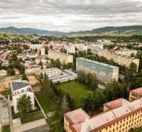 An aerial view of the Barracks Quarter in Brezno shows residential buildings and greenery.