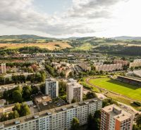 Aerial view of Plots - housing in the Barracks District in Brezno with a stadium and buildings.