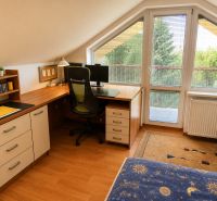 A workspace in the attic of a family house with a wooden decor floor.