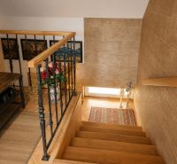 Interior of a family house with a wooden staircase and decorative elements.