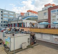 A building in Banská Bystrica with service facilities and a parking lot full of cars.