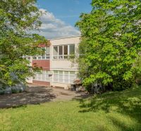 A building in Banská Bystrica surrounded by greenery and lawn.