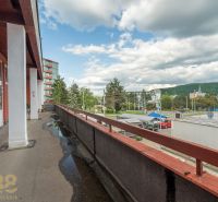 A balcony of a building in Banská Bystrica with a view of the street and greenery.