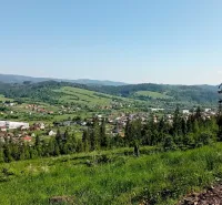 Raková surrounded by agricultural and forest lands, including diverse vegetation and village houses.